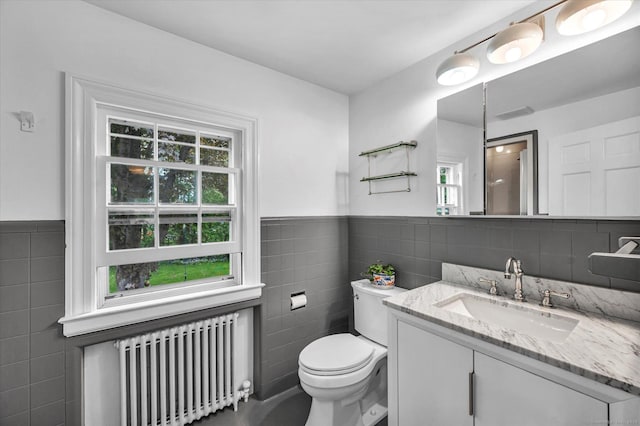 10 Meadowbrook Rd, Hamden, CT 06517 - bathroom featuring radiator heating unit, tile walls, toilet, a wainscoted wall, and vanity