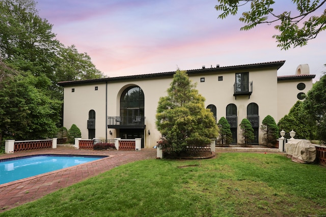 46 Mountain Farms Rd, West Hartford, CT 06117 - rear view of house featuring a balcony, a lawn, and stucco siding