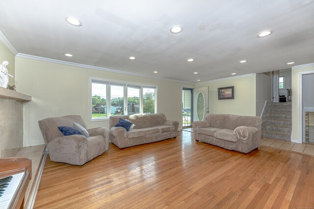 living area featuring ornamental molding, light wood-style flooring, recessed lighting, and stairs