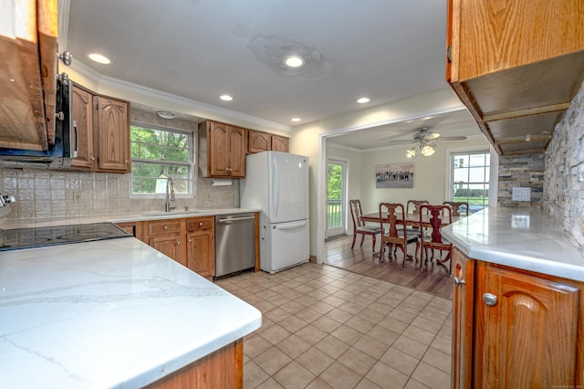 kitchen with dishwasher, a sink, freestanding refrigerator, light tile patterned floors, and backsplash