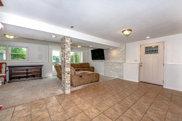 living room with a textured ceiling, light colored carpet, decorative columns, recessed lighting, and light tile patterned floors