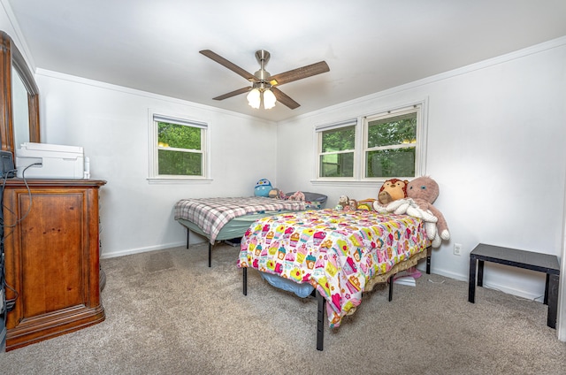 carpeted bedroom with multiple windows, ornamental molding, baseboards, and ceiling fan