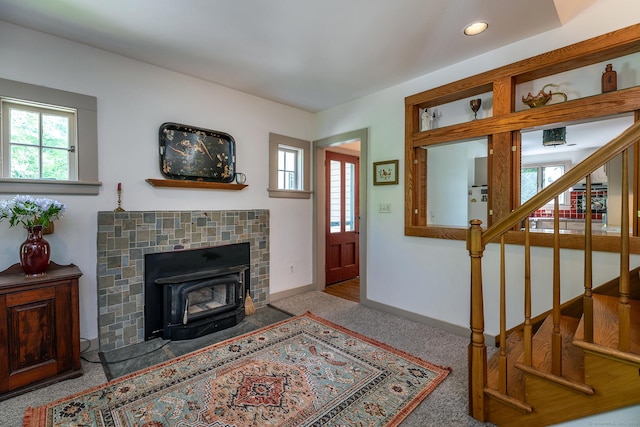 living room featuring plenty of natural light, stairs, carpet, a wood stove, and recessed lighting