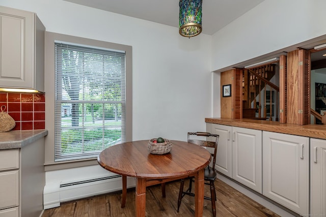 dining space featuring a baseboard radiator and wood finished floors
