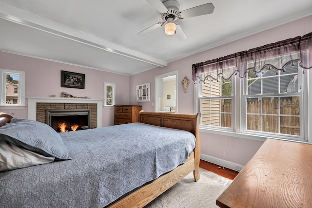 4 Hockanum Dr, East Hartford, CT 06118 - bedroom featuring wood finished floors, a brick fireplace, beamed ceiling, crown molding, and a ceiling fan