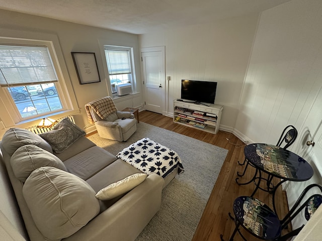 living room featuring wood finished floors, baseboards, and cooling unit