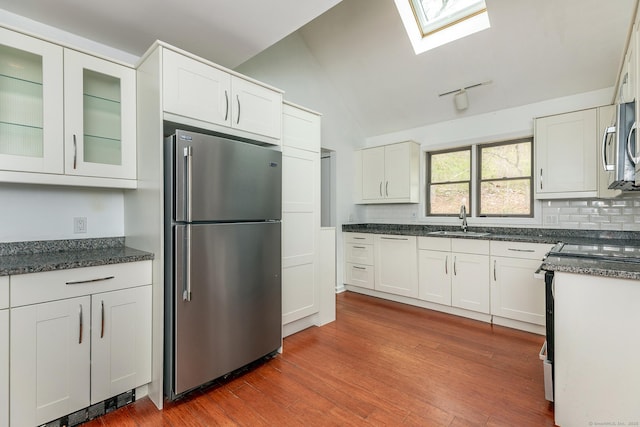 433 Kent Cornwall Rd Unit 14, Kent, CT 06757 - kitchen with stainless steel appliances, a sink, white cabinets, backsplash, and vaulted ceiling