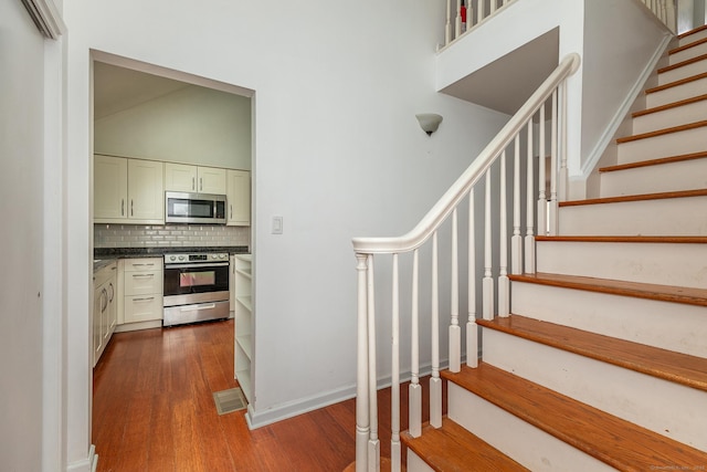 433 Kent Cornwall Rd Unit 14, Kent, CT 06757 - staircase featuring wood finished floors, a high ceiling, and baseboards