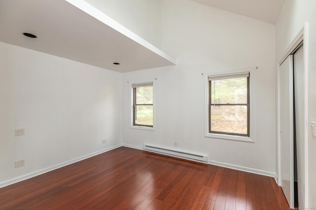 433 Kent Cornwall Rd Unit 14, Kent, CT 06757 - unfurnished bedroom with a baseboard radiator, wood-type flooring, baseboards, a closet, and vaulted ceiling
