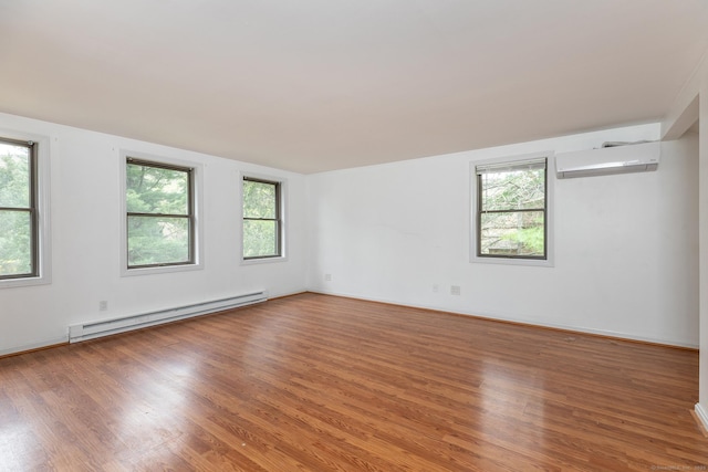 433 Kent Cornwall Rd Unit 14, Kent, CT 06757 - spare room with baseboard heating, a wall unit AC, wood finished floors, and baseboards