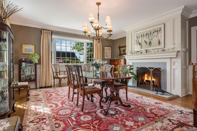 37 Lantern Hill Rd, Madison, CT 06443 - dining area with wood finished floors, a chandelier, ornamental molding, and a warm lit fireplace