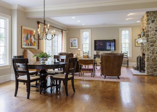 37 Lantern Hill Rd, Madison, CT 06443 - dining area with wood finished floors, a chandelier, crown molding, and a stone fireplace