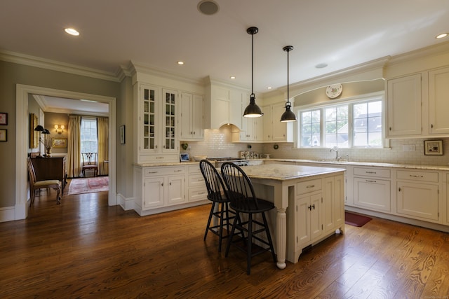37 Lantern Hill Rd, Madison, CT 06443 - kitchen featuring a center island, white cabinetry, dark wood finished floors, a breakfast bar area, and crown molding