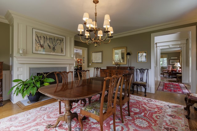 37 Lantern Hill Rd, Madison, CT 06443 - dining space featuring wood finished floors, ornamental molding, a chandelier, and a fireplace