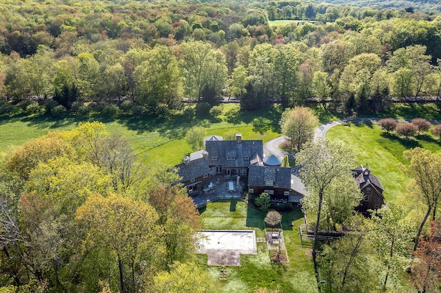 aerial view of property and surrounding area featuring a heavily wooded area