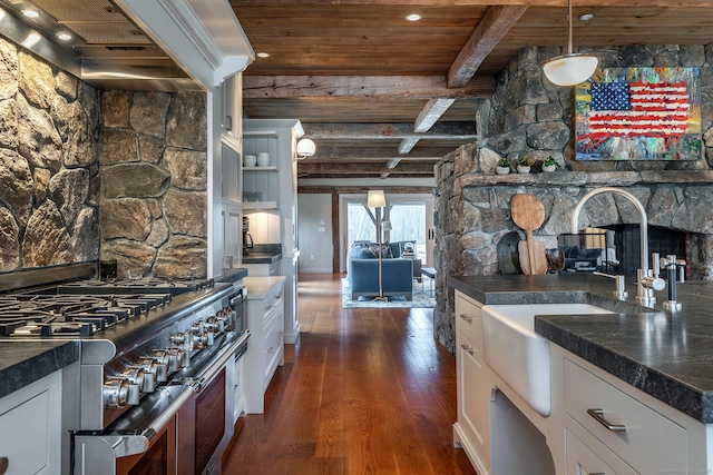 kitchen with double oven range, dark wood-style flooring, wooden ceiling with exposed beams, a sink, and white cabinetry