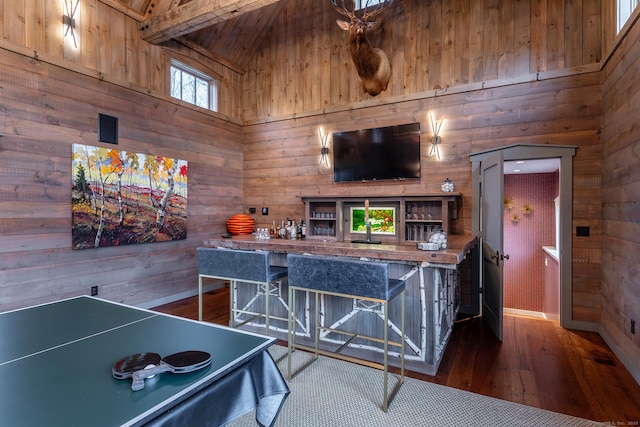 playroom featuring wooden walls, wood finished floors, and a high ceiling