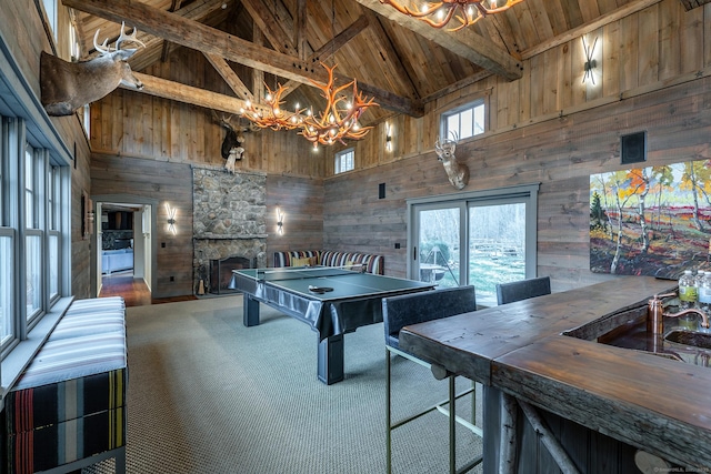 recreation room featuring a chandelier, high vaulted ceiling, wooden walls, wooden ceiling with exposed beams, and a fireplace