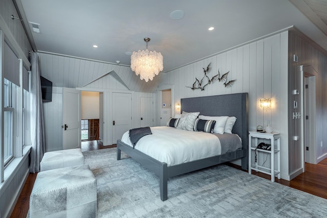 bedroom featuring a chandelier, wood finished floors, and lofted ceiling