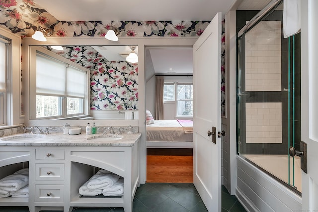 ensuite bathroom featuring wallpapered walls, tile patterned flooring, tiled shower / bath combo, and double vanity
