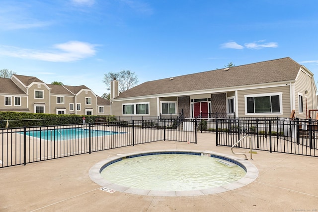 community pool with fence and a patio