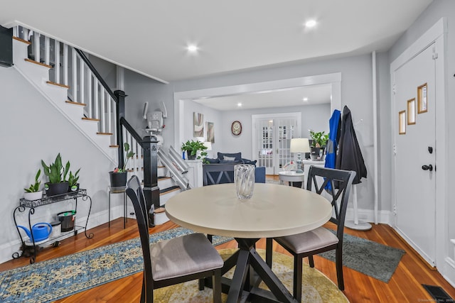 dining space with stairs, wood finished floors, baseboards, and recessed lighting