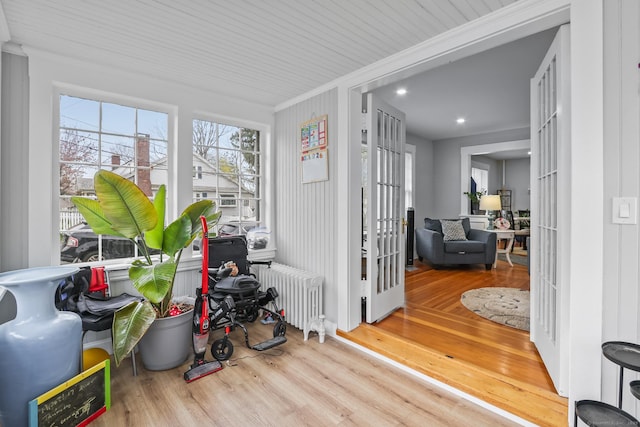 sunroom / solarium featuring radiator heating unit and french doors