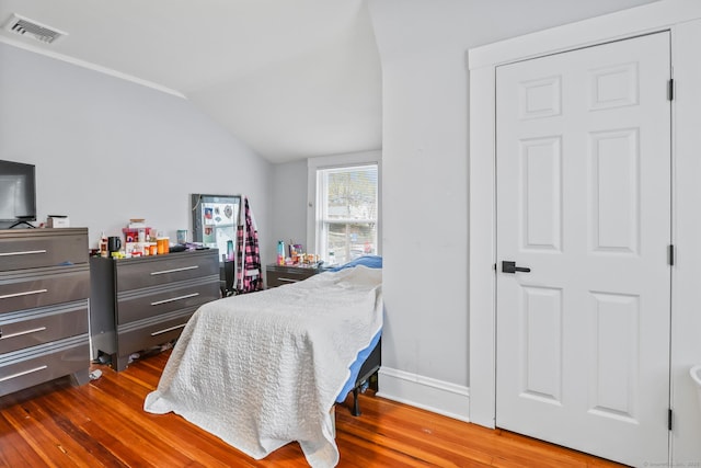bedroom featuring dark wood-style floors and lofted ceiling
