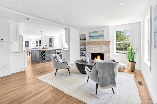 706 Judd St, Fairfield, CT 06825 - living room featuring light wood-style flooring, a brick fireplace, and recessed lighting