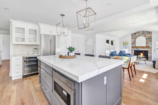706 Judd St, Fairfield, CT 06825 - kitchen with wine cooler, stainless steel appliances, gray cabinets, light wood finished floors, and a center island