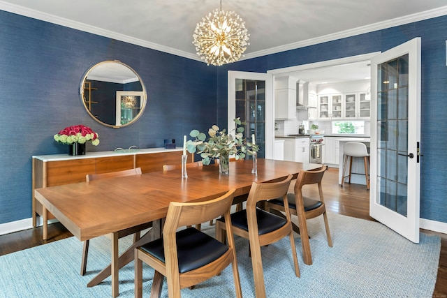 dining area featuring a chandelier, dark wood-style flooring, baseboards, ornamental molding, and french doors