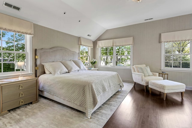bedroom with light wood-style flooring, multiple windows, vaulted ceiling, and wallpapered walls