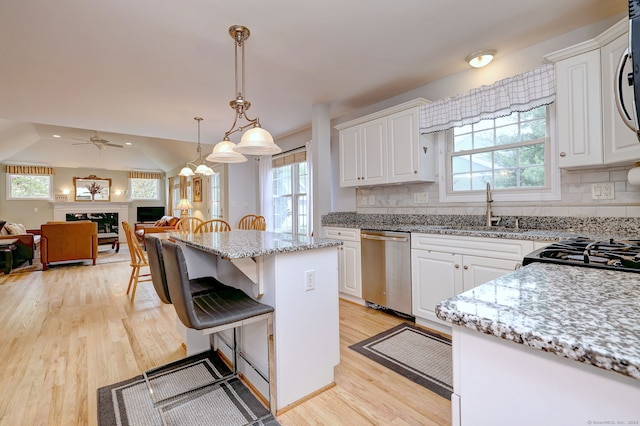 539 Plains Rd, Milford, CT 06461 - kitchen featuring stainless steel dishwasher, a sink, light wood finished floors, and white cabinetry