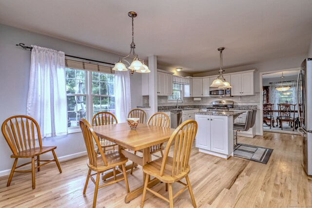 539 Plains Rd, Milford, CT 06461 - dining room featuring a chandelier, light wood finished floors, and baseboards