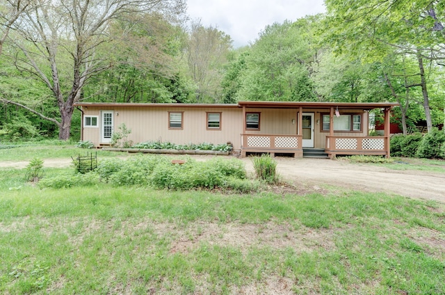 view of front of property featuring a porch and a wooded view