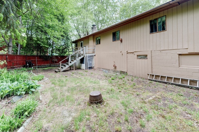 view of yard featuring fence and stairs