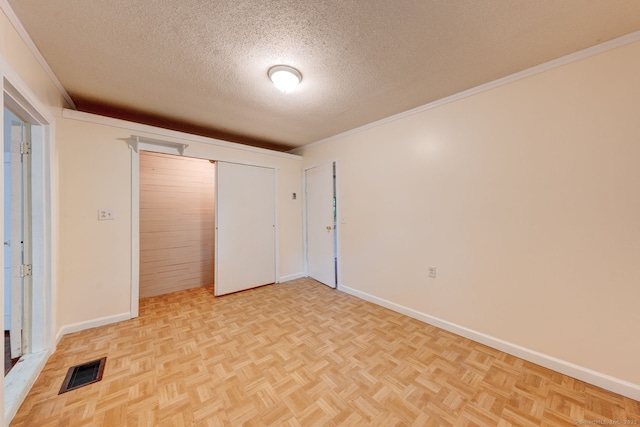 unfurnished bedroom with a textured ceiling, baseboards, a closet, and crown molding