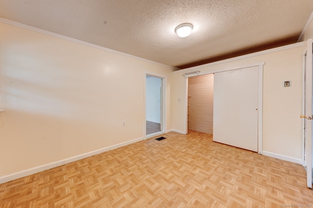 unfurnished bedroom featuring a textured ceiling, baseboards, ornamental molding, and a closet