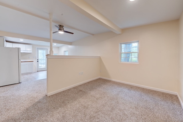 basement featuring freestanding refrigerator, light colored carpet, healthy amount of natural light, baseboards, and recessed lighting