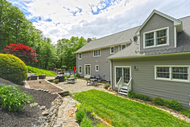 250 Wooding Hill Rd, Bethany, CT 06524 - back of house featuring entry steps, a lawn, a patio area, a shingled roof, and a chimney