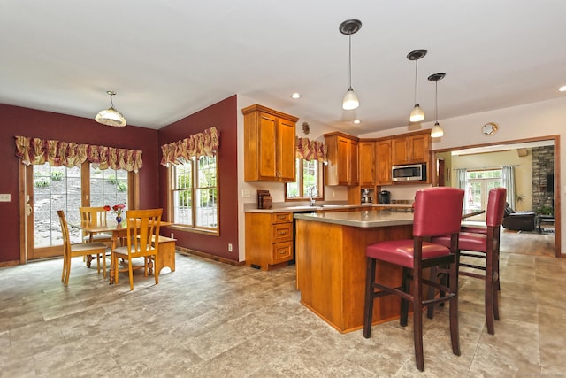 250 Wooding Hill Rd, Bethany, CT 06524 - kitchen featuring stainless steel microwave, brown cabinets, healthy amount of natural light, and hanging light fixtures