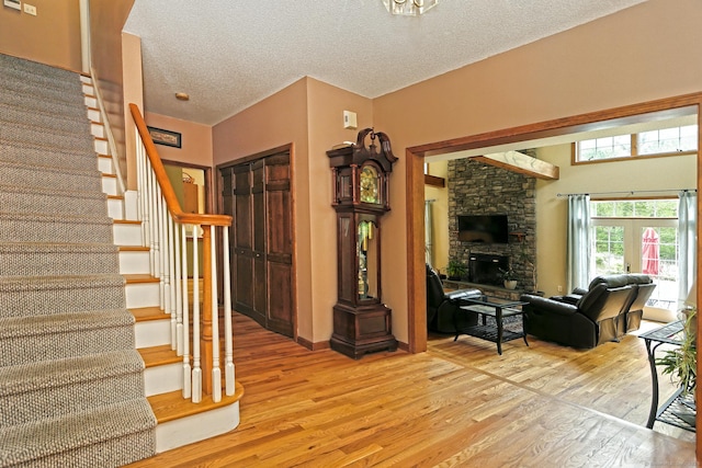 250 Wooding Hill Rd, Bethany, CT 06524 - staircase with wood finished floors, a fireplace, and a textured ceiling