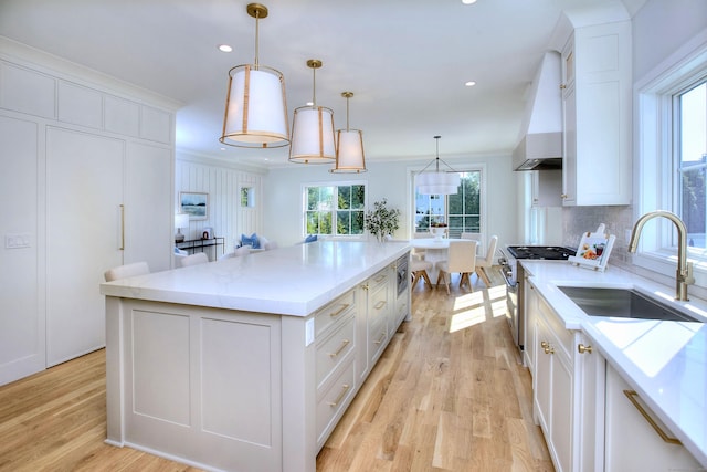 450 Penfield Rd, Fairfield, CT 06824 - kitchen with appliances with stainless steel finishes, a sink, white cabinetry, wall chimney exhaust hood, and light wood-style flooring