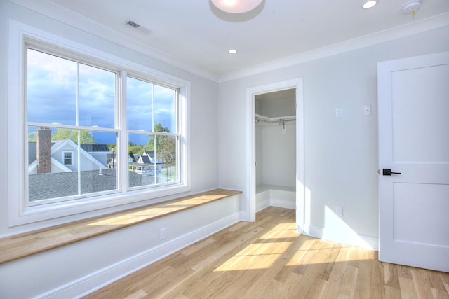 450 Penfield Rd, Fairfield, CT 06824 - unfurnished bedroom with baseboards, light wood-type flooring, multiple windows, ornamental molding, and a spacious closet