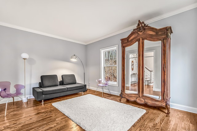 living area with crown molding, baseboards, and wood finished floors