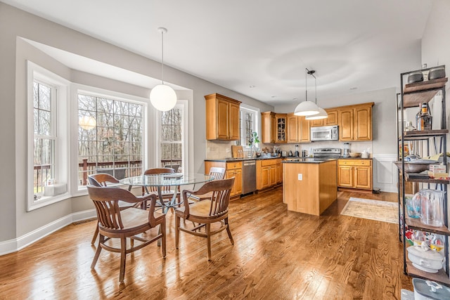 38 Marlin Rd, Newtown, CT 06482 - kitchen featuring appliances with stainless steel finishes, a kitchen island, wood finished floors, dark countertops, and decorative light fixtures