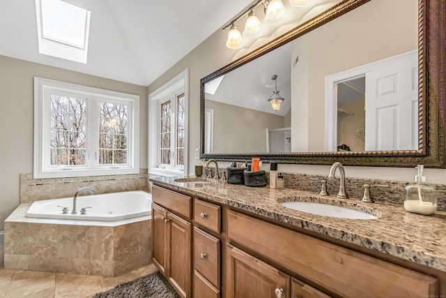 bathroom with a skylight, lofted ceiling, a garden tub, and double vanity