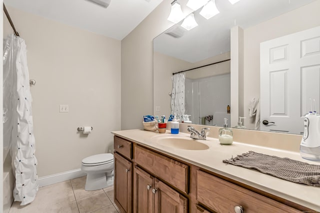 bathroom with tile patterned flooring, a skylight, toilet, vanity, and baseboards
