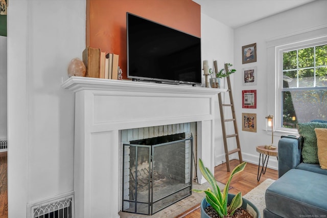 19 Orpington St, Hamden, CT 06517 - living room featuring a brick fireplace, wood finished floors, and baseboards