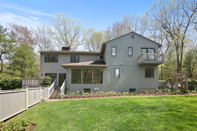 back of property featuring a balcony, a yard, a shingled roof, and a chimney